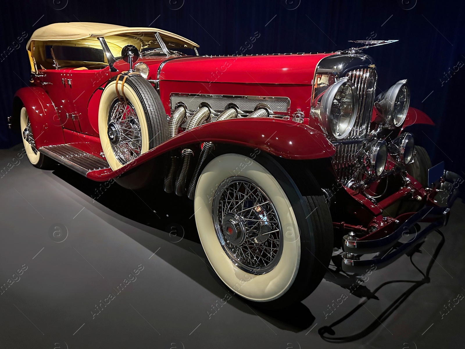 Photo of Beautiful red retro car in salon. Vintage automobile