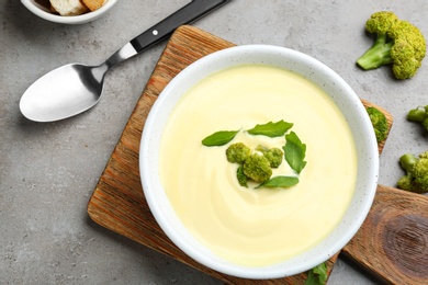Photo of Flat lay composition with bowl of cheese cream soup and broccoli on grey table