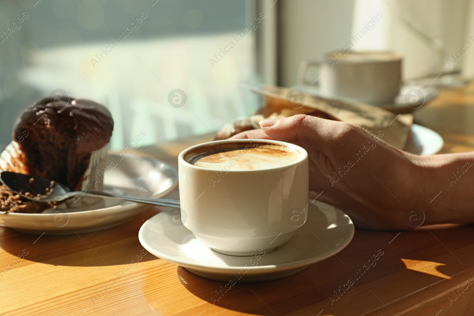 Photo of Woman with cup of fresh aromatic coffee at table in cafe