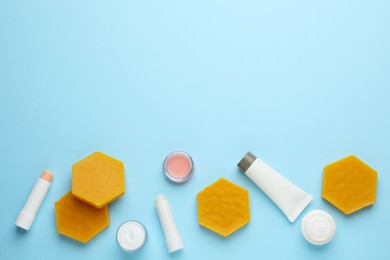 Photo of Flat lay composition with beeswax and cosmetic products on light blue background. Space for text
