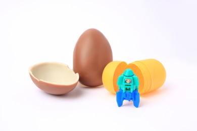 Photo of Slynchev Bryag, Bulgaria - May 24, 2023: Halves of Kinder Surprise Egg, plastic capsule and toy space rocket isolated on white