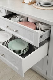 Clean plates, bowl and cups in drawers indoors