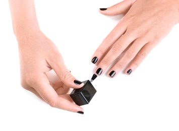 Woman applying nail polish on white background, closeup