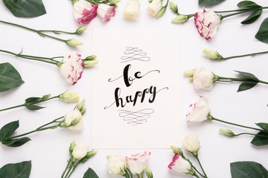 Photo of Frame of beautiful flowers and paper card with handwritten text Be happy on white background, flat lay