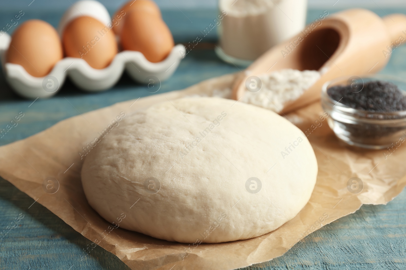 Photo of Raw dough with poppy seeds on table, closeup