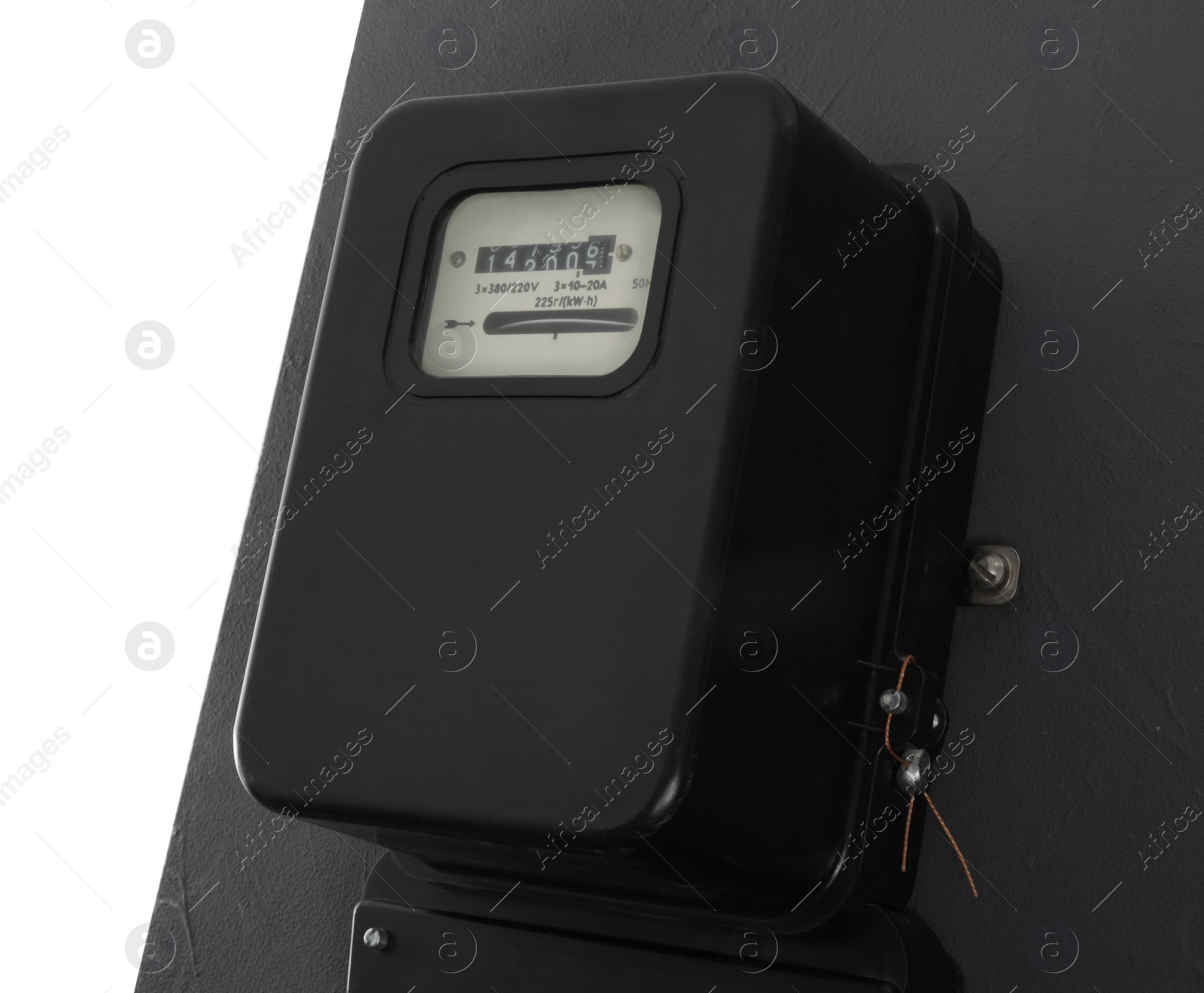 Photo of Electricity meter on grey wall against white background. Space for text