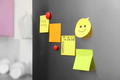 Paper sheets and magnets on refrigerator door indoors