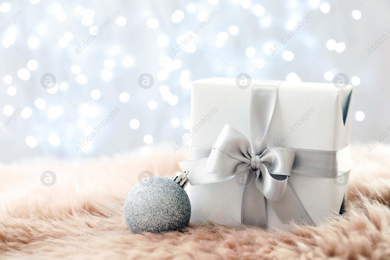 Photo of Christmas gift on fur against blurred background