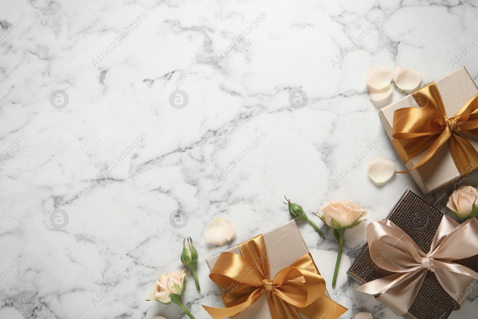 Photo of Gift boxes and beautiful roses on white marble background, flat lay. Space for text