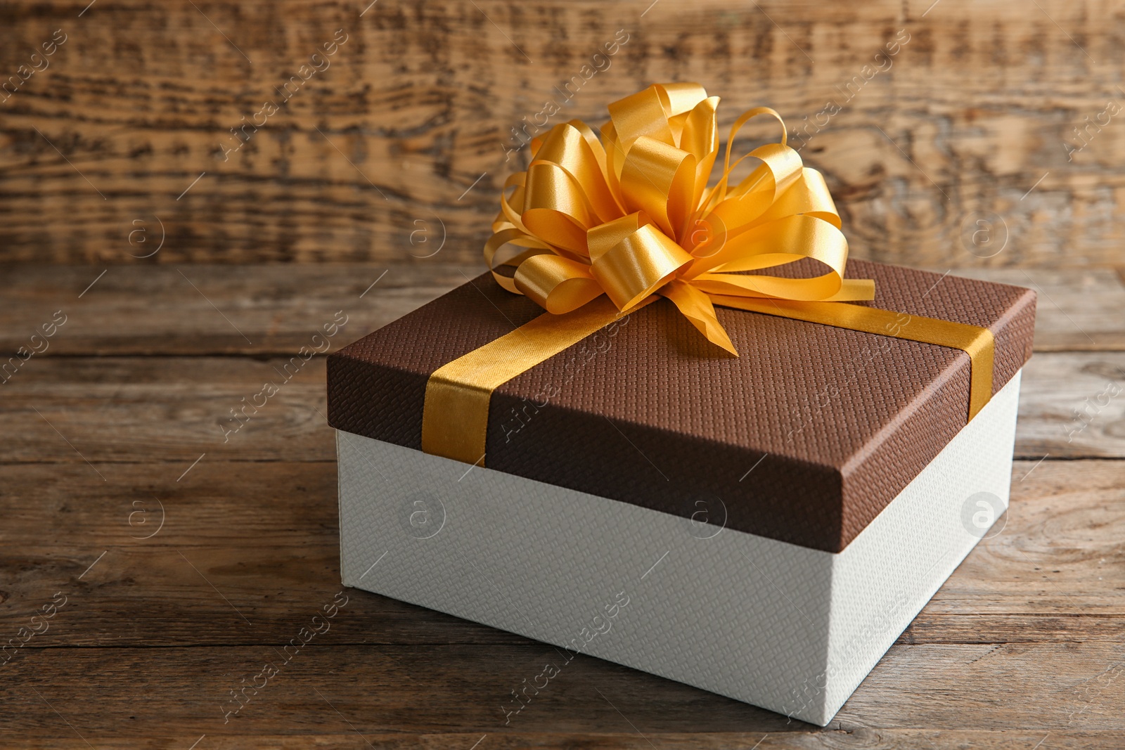 Photo of Beautiful gift box with bow on wooden table