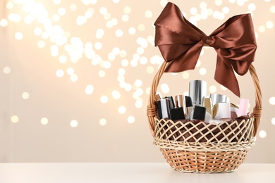 Photo of Wicker basket with cosmetics as present against blurred festive lights. Space for text