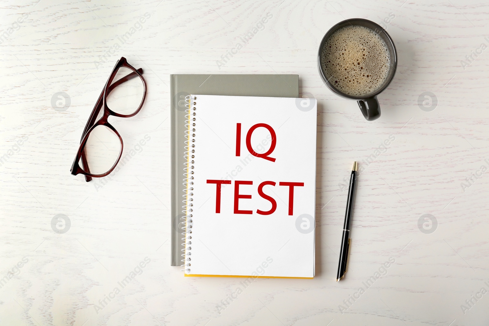 Image of Notebook with text IQ Test, glasses, pencil and cup of coffee on white wooden table, flat lay
