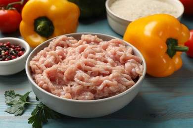 Making stuffed peppers. Ground meat and other ingredients on light blue wooden table, closeup