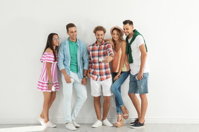 Group of young people taking selfie near white wall