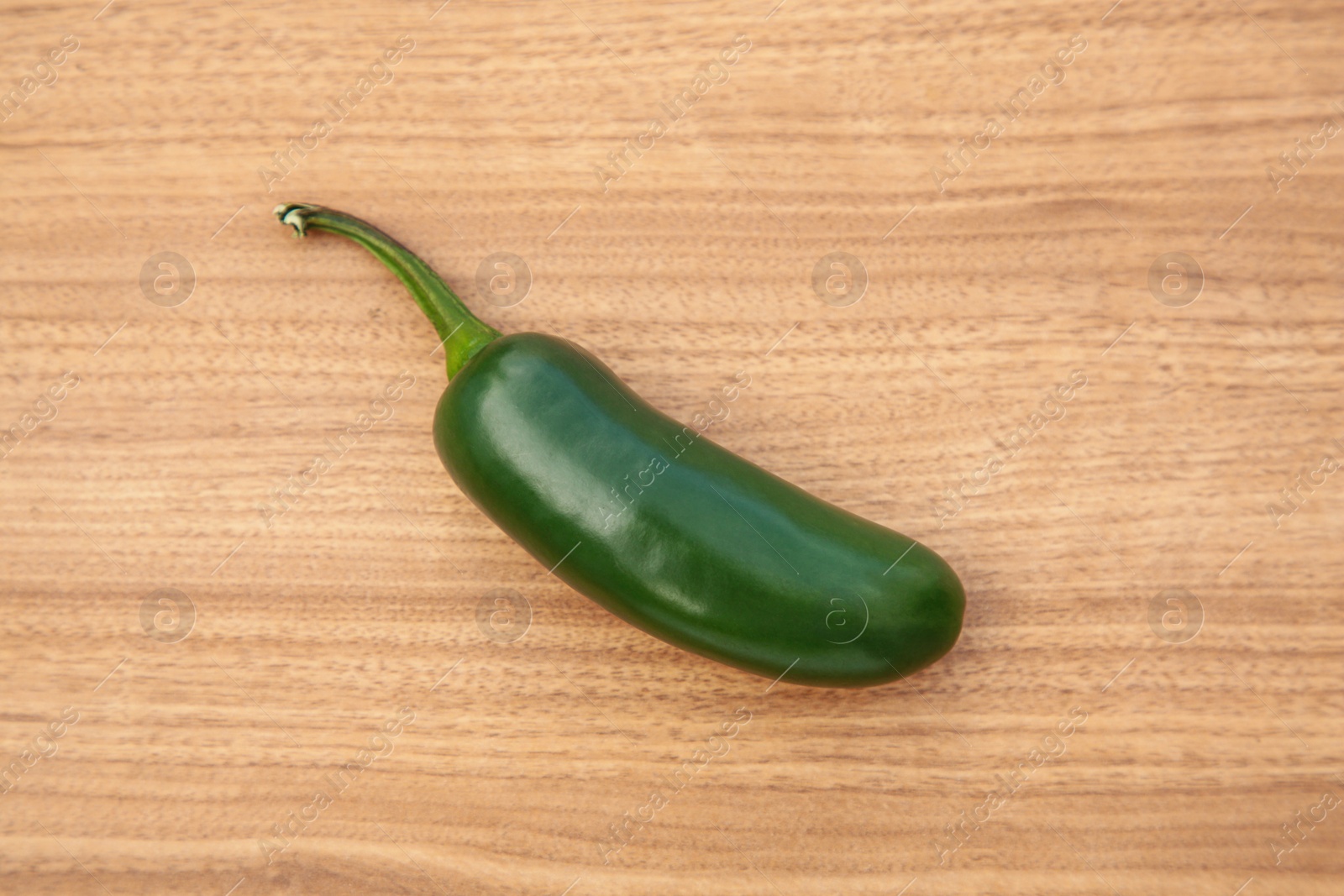 Photo of Fresh green jalapeno pepper on wooden table, top view