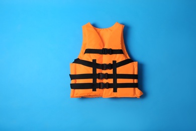 Orange life jacket on blue background. Personal flotation device