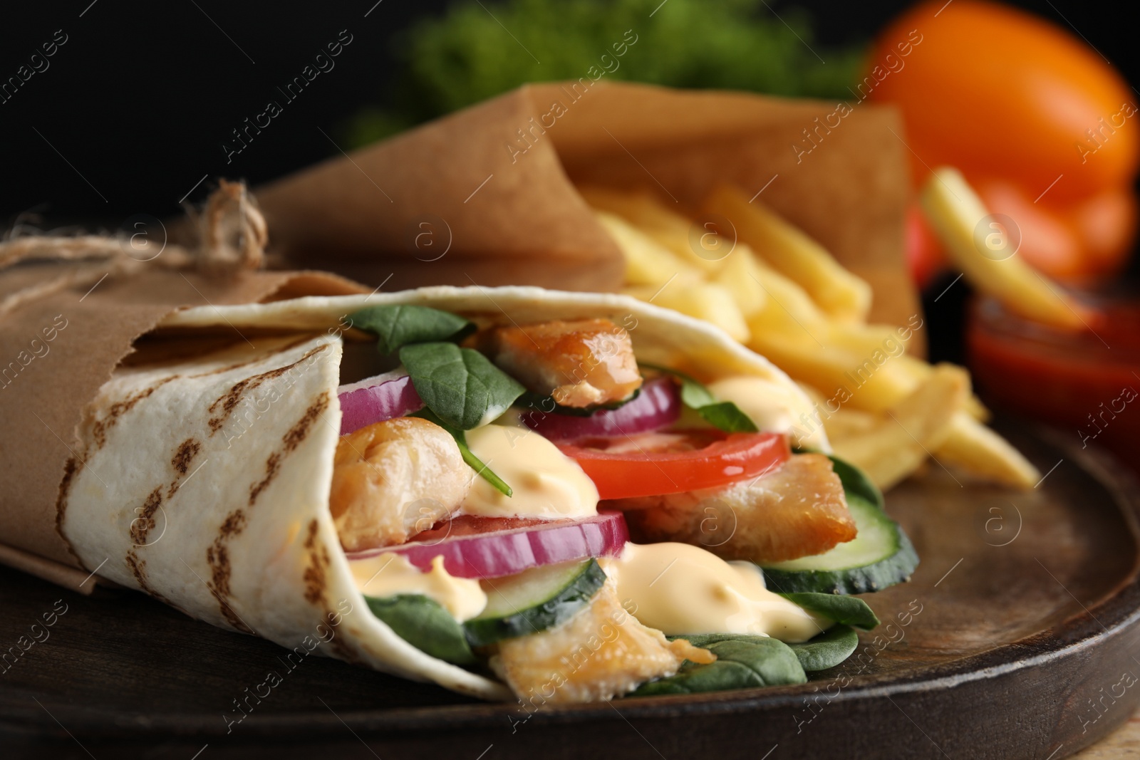 Photo of Delicious chicken shawarma on wooden board, closeup