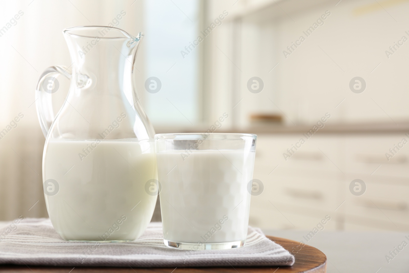 Photo of Delicious fresh milk on wooden table indoors. Space for text