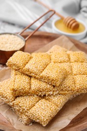 Wooden tray with delicious sweet kozinaki bars and sesame seeds, closeup