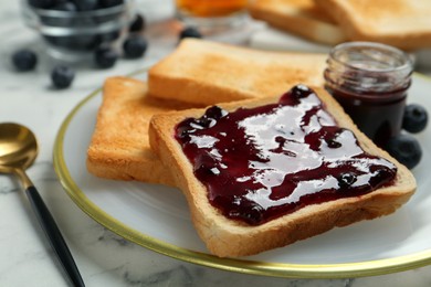 Photo of Delicious toasts with jam served on white marble table, closeup