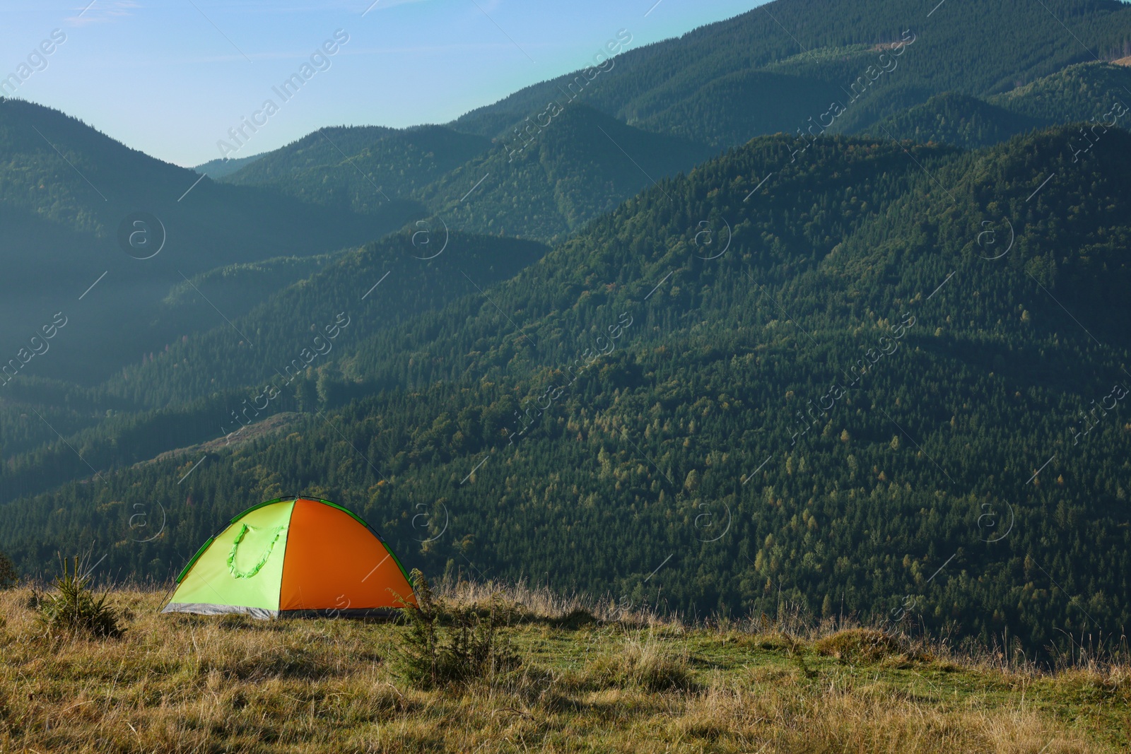 Photo of Picturesque mountain landscape with camping tent in morning