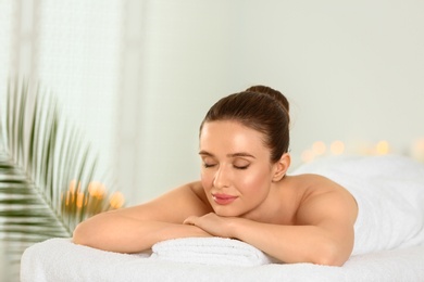 Beautiful young woman relaxing in spa salon