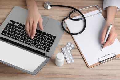 Photo of Doctor working at desk in office, above view. Medical service