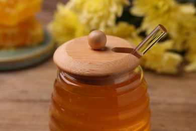 Photo of Sweet golden honey in jar on table, closeup