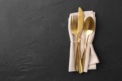 Photo of Set of stylish cutlery and napkin on black table, top view. Space for text