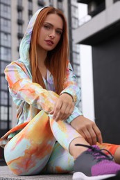 Photo of Beautiful woman in stylish gym clothes posing on street