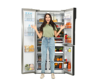 Photo of Excited young woman near open refrigerator on white background