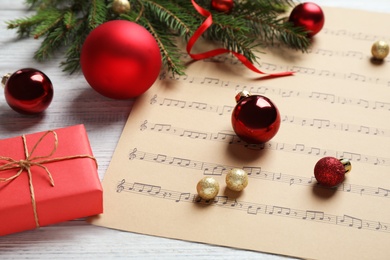 Christmas decorations and music sheet on white wooden table