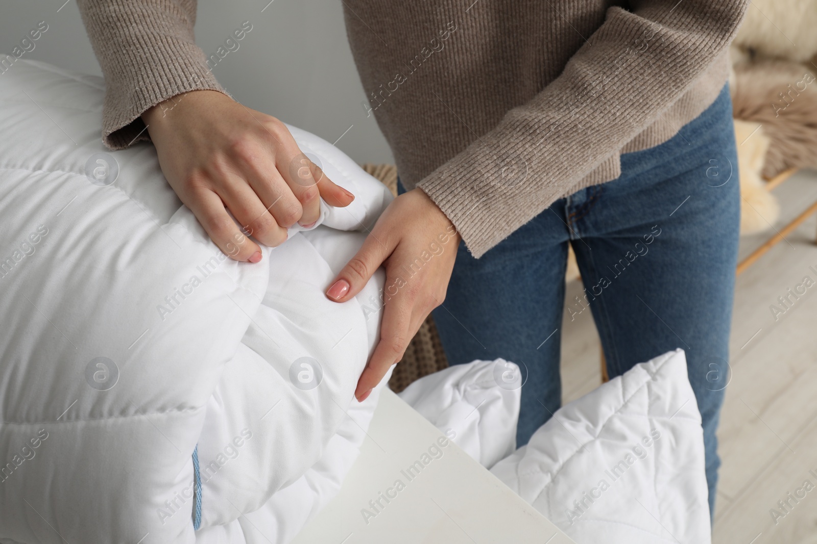 Photo of Woman choosing duvet in home textiles store, closeup