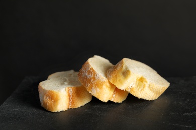 Photo of Tasty sliced wheat bread on black table