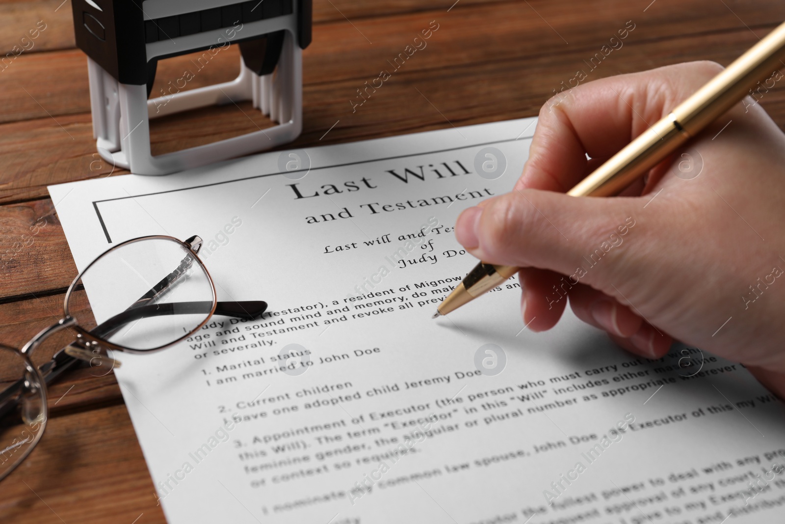 Photo of Woman signing Last Will and Testament at wooden table, closeup