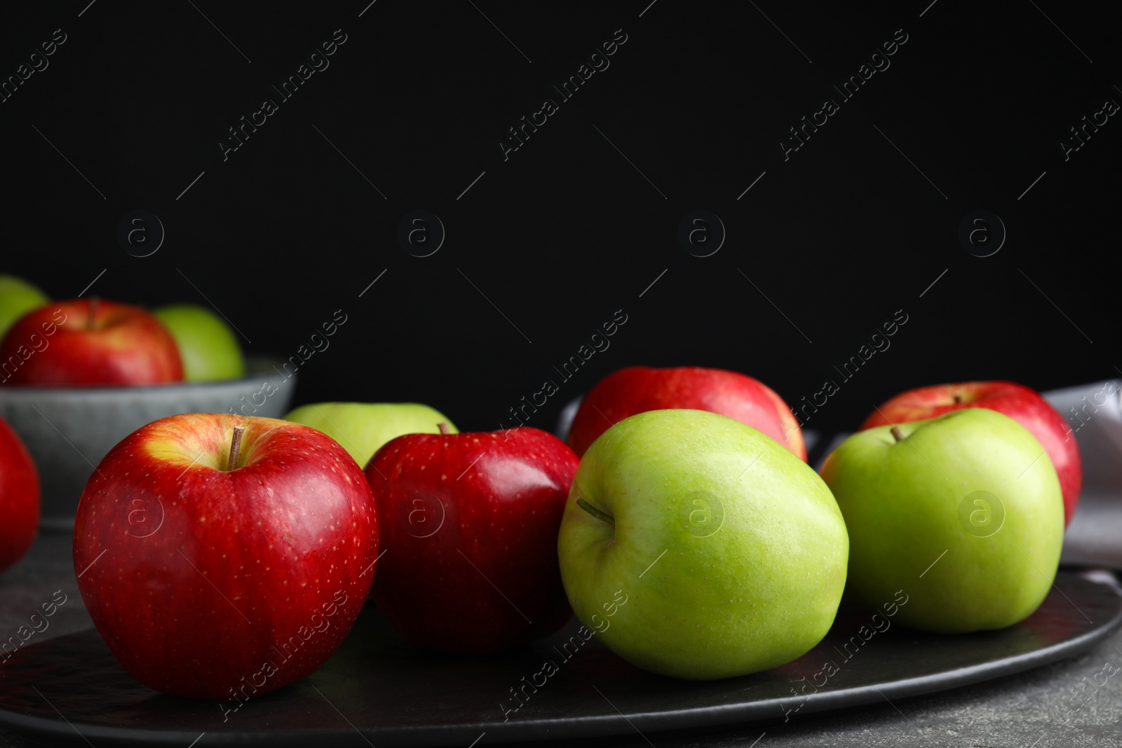 Photo of Fresh ripe green apples on slate plate, closeup