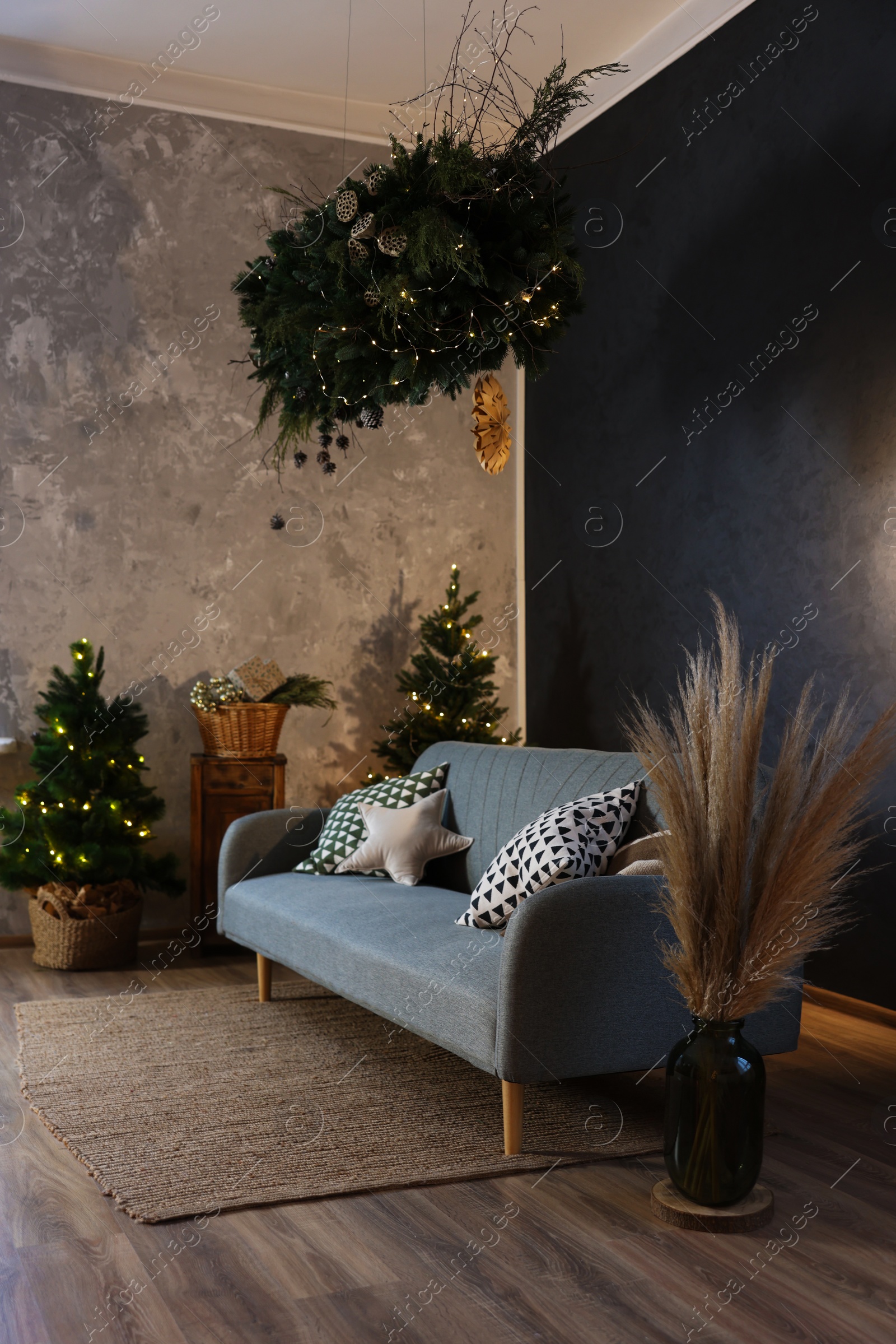 Photo of Stylish living room with comfortable sofa and Christmas decor. Interior design