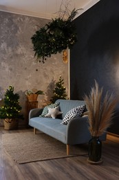 Photo of Stylish living room with comfortable sofa and Christmas decor. Interior design