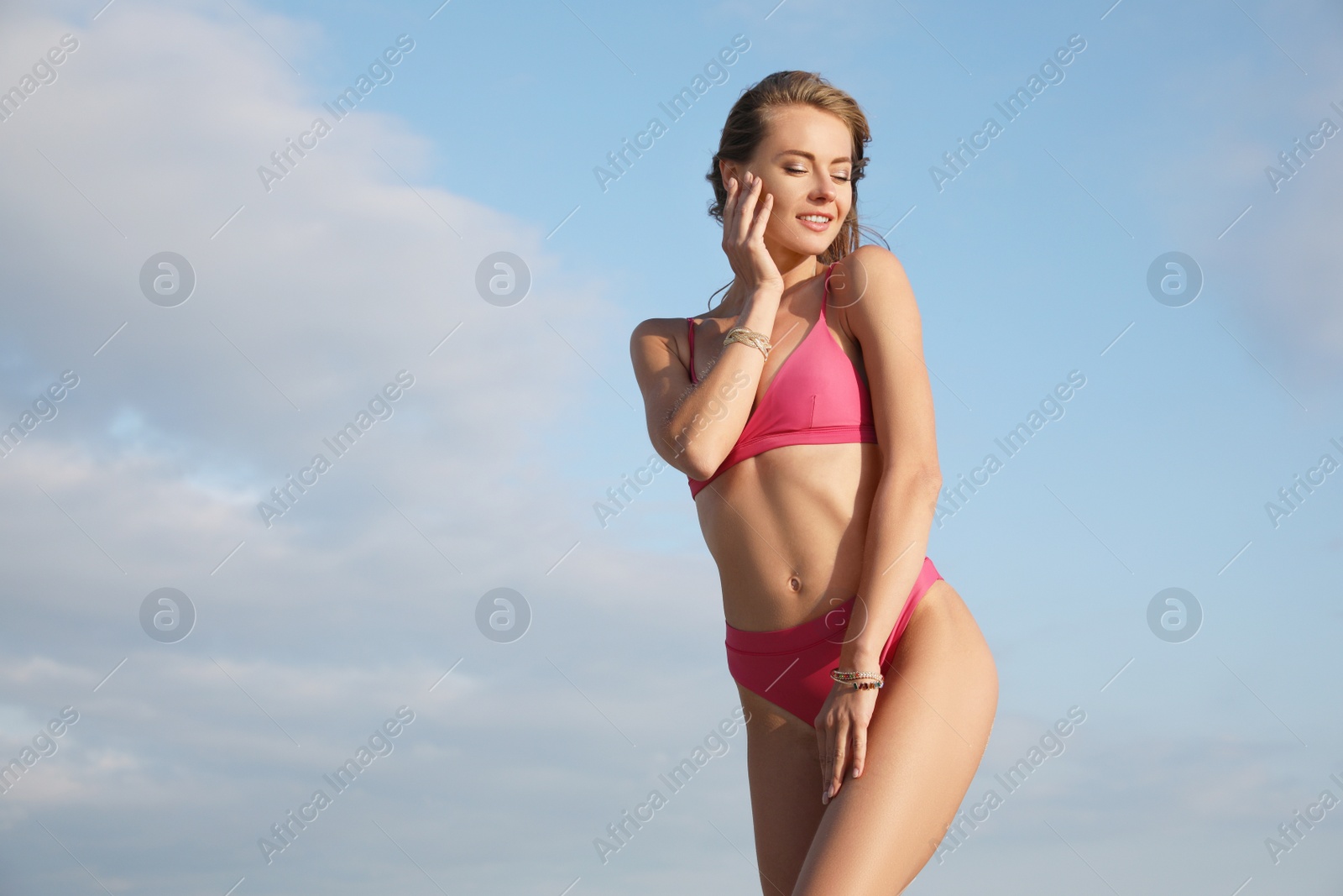 Photo of Attractive woman with beautiful body in bikini against blue sky. Space for text