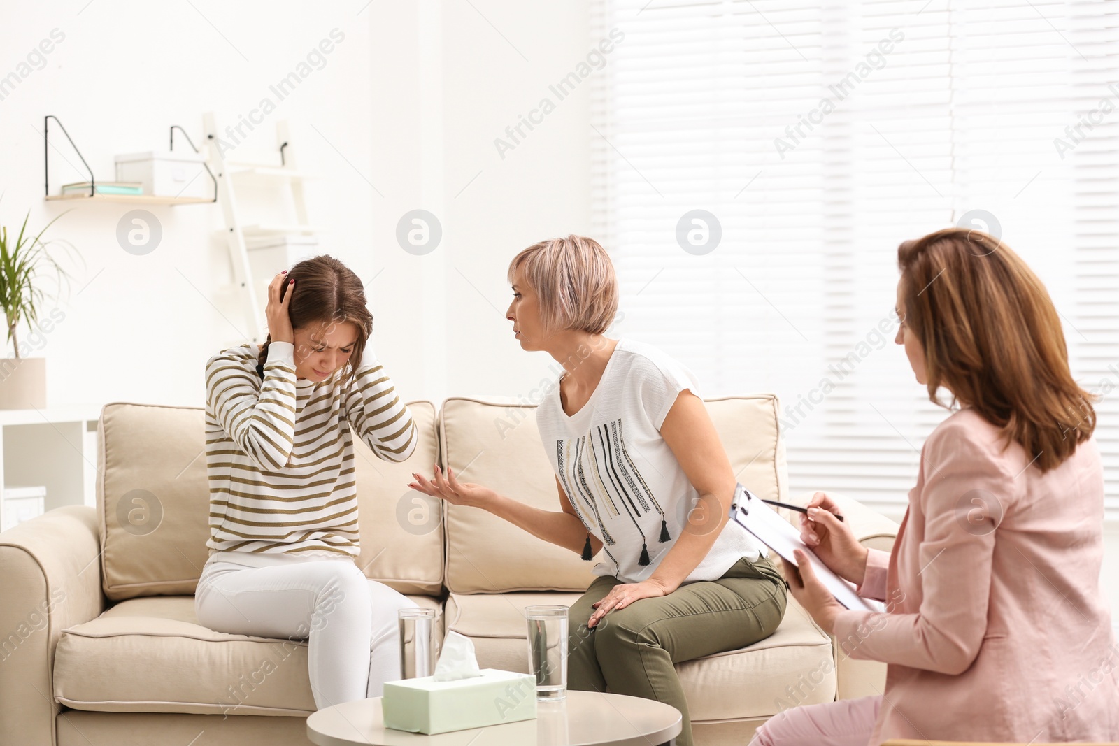 Photo of Psychotherapist working with teenage girl and her mother in office