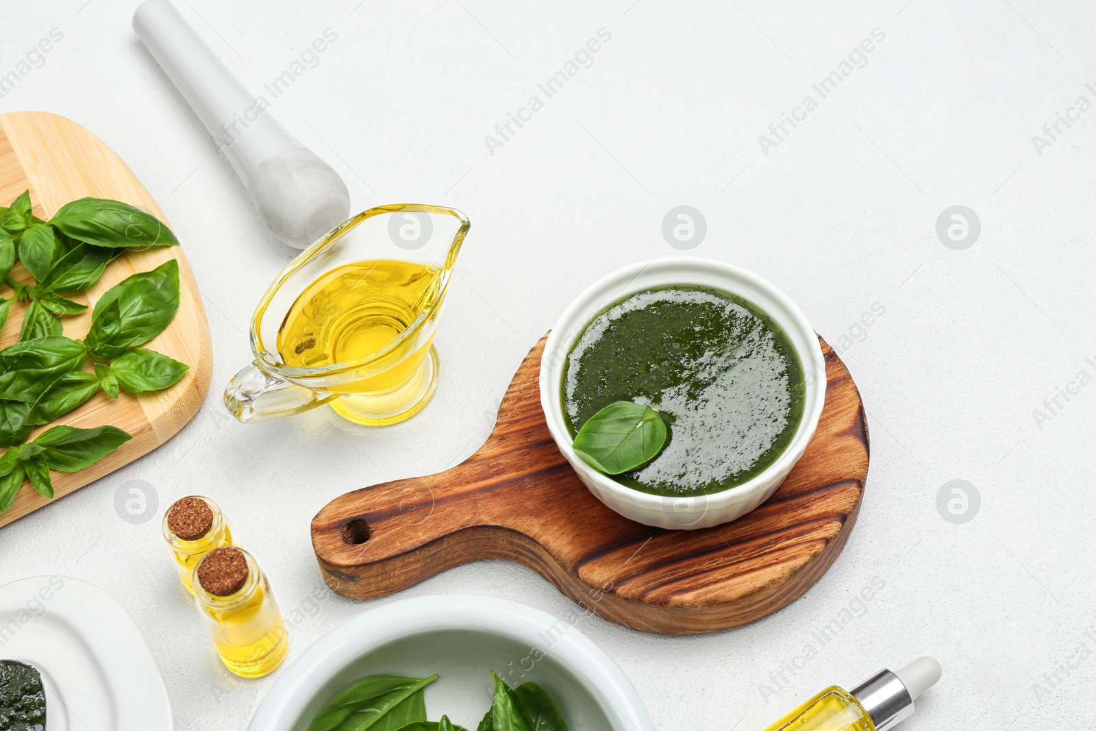 Photo of Composition with basil oil and leaves on white table