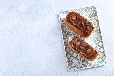 Photo of Tasty puff pastry. Supreme croissants with chocolate chips and cream on grey table, top view. Space for text