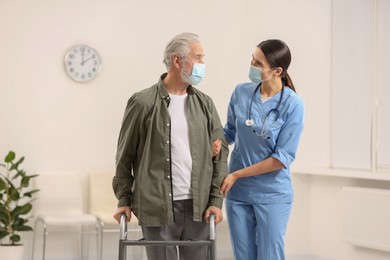 Photo of Young nurse supporting elderly patient in hospital