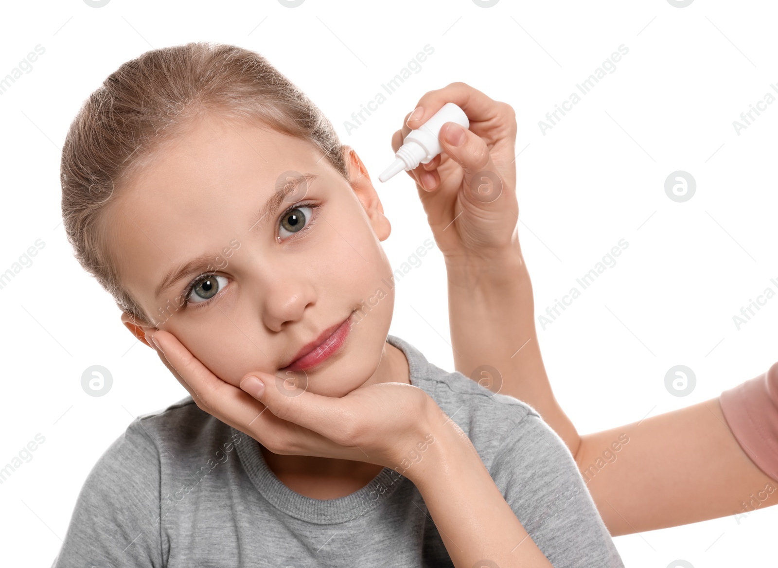 Photo of Mother dripping medication into daughter's ear on white background