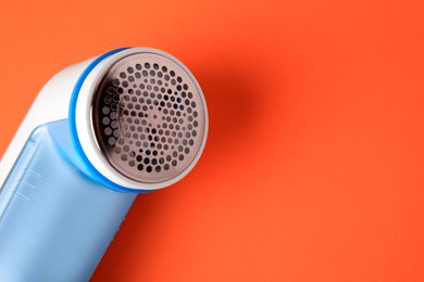 Photo of Fabric shaver on orange background, closeup. Space for text