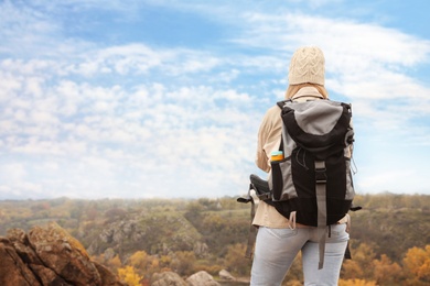 Photo of Traveler with backpack enjoying beautiful view on sunny day. Autumn vacation