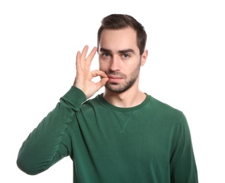 Man zipping his mouth on white background. Using sign language