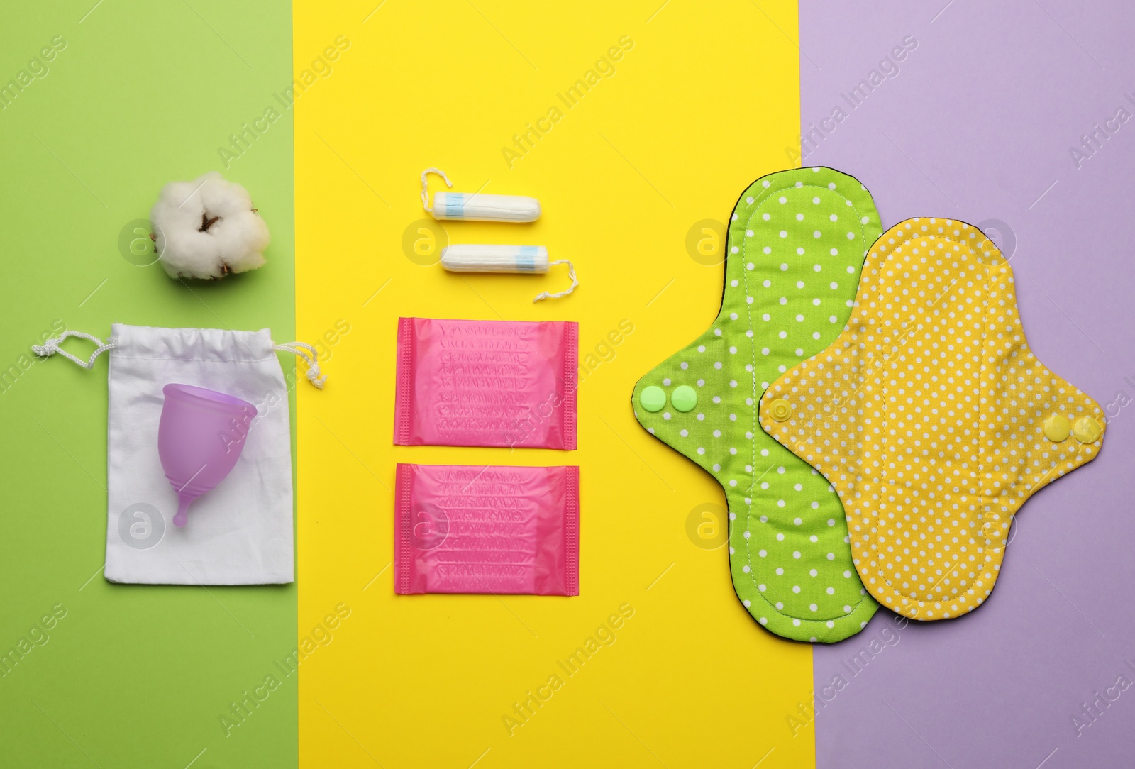 Photo of Cloth menstrual pad near other reusable and disposable female hygiene products on color background, flat lay