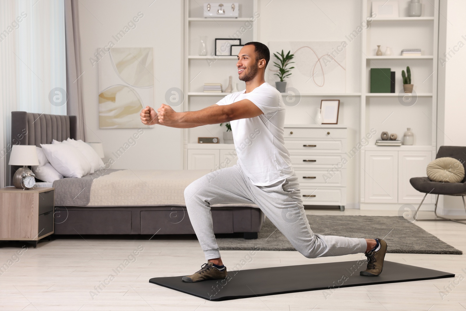 Photo of Man doing morning exercise on fitness mat at home