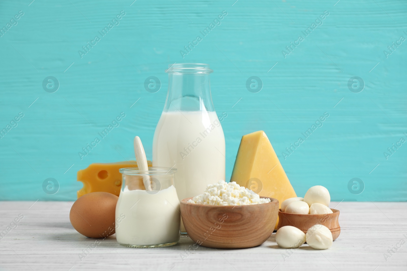 Photo of Different dairy products on white table against blue background